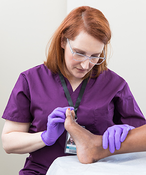 Proveedor de atención médica revisando el pie de una mujer.