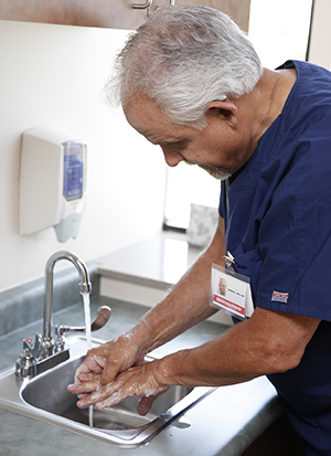 Una proveedora de atención médica se lava las manos.