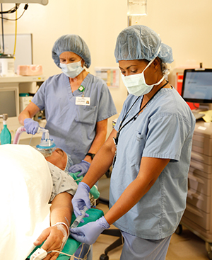 Healthcare providers in operating room preparing man for surgery.