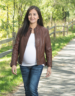 Pregnant woman walking in a park.
