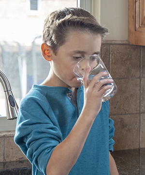 Boy drinking glass of water.