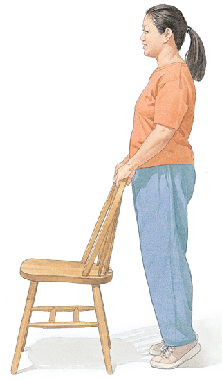 Woman standing on tiptoes and holding on to chair for support.