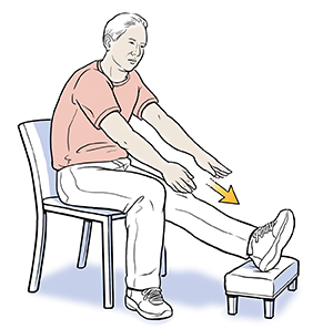Un hombre sentado con un pie en un taburete haciendo el ejercicio de estiramiento de piernas.