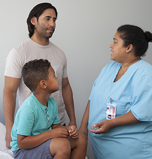 Un proveedor de atención médica habla con un hombre y un niño.