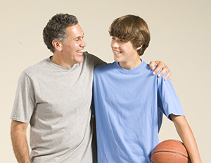 Hombre y adolescente con pelota de básquetbol.