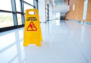 Señal amarilla indicando precaución por piso mojado.