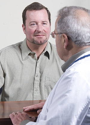 Hombre hablando con un proveedor de atención médica.