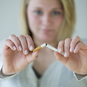 Mujer quebrando un cigarrillo.