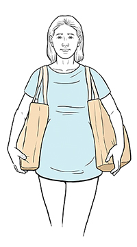 Mujer embarazada que lleva bolsas de manera segura.