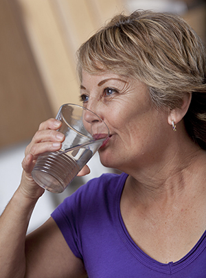 Mujer bebiendo un vaso de agua.